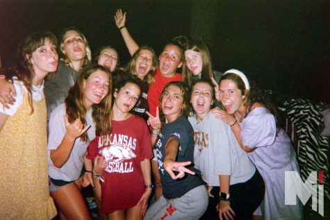 Standing on the back deck of the cabin, juniors Lexi Kurt, Stella Cahalan, Claire Winklhofer and Allison Brentano gather with their cabin at Camp Barnabas as they smile at the disposable camera. The missionaries had just finished their nightly prayers and reflections.