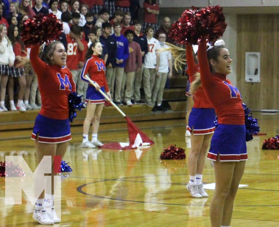 With smiles on their faces, sophomore Alanah Garcia and junior Ava Fortin perform their cheer routine at the pep assembly on Nov. 19. The cheer team competed at state the following day in Topeka.