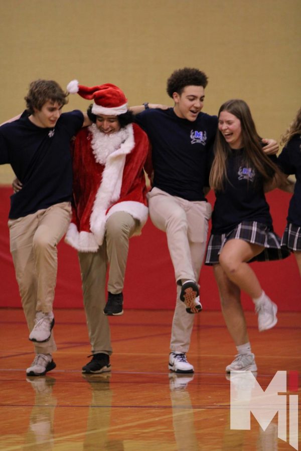 Dressed up as Santa, senior Alex Raygoza leads the Rost herd in a kick-line during their dance.