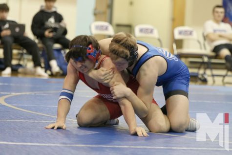 In the final match of the meet, Griffin Loehr concentrates his strength to prevent getting pinned down by the opponent. 