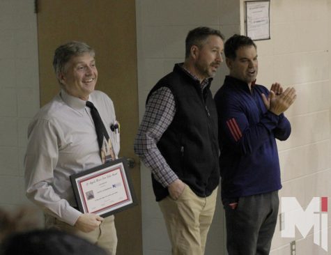 With a smile on his face, science teacher Scott Anderson holds his St. Angela Merici Award. The award was given out to only seven teachers in the school.