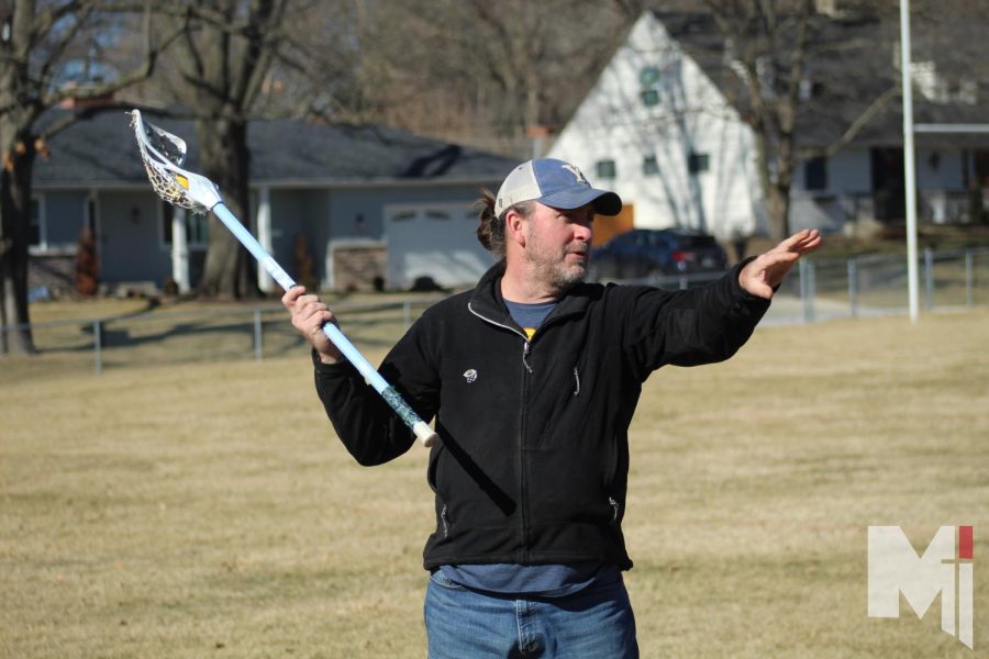 Demonstrating the way to use a lacrosse stick, head coach Ross Dessert shows players tips to practice at the throw around on Jan. 29 and Jan. 30. “I hope to get everyone to fall in love with it.,” Dessert said.