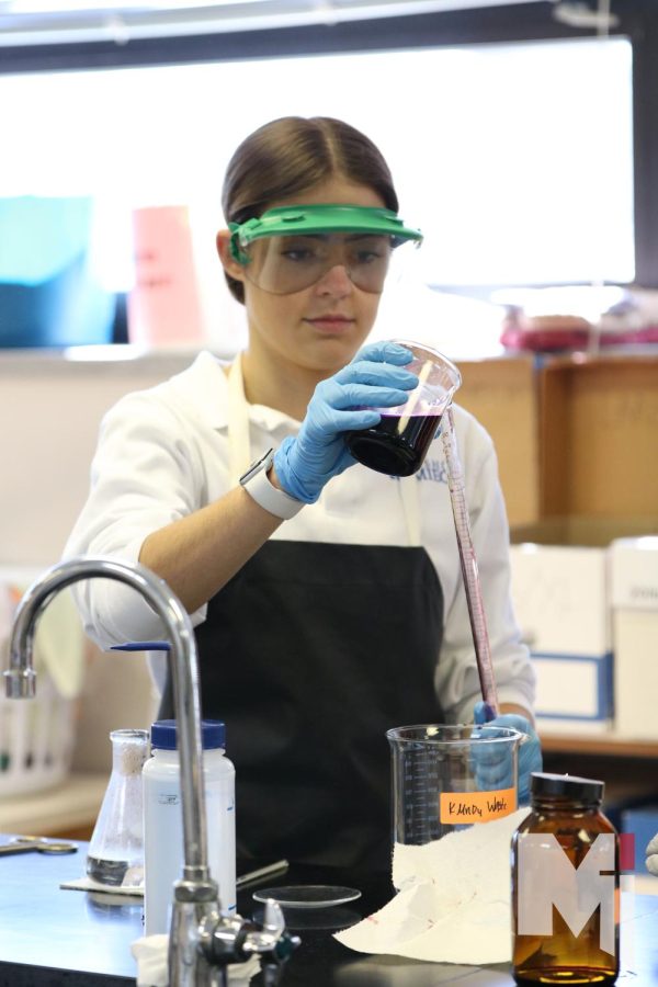 While using a technique called titration in chemistry class, junior Ava Fortin pours potassium permanganate into a tube. By doing this experiment Fortin was able to figure out how to find the percent of iron in an unknown substance. “Titrations is my favorite because they are kind of interesting and its kind of like a guessing game,” Fortin said.