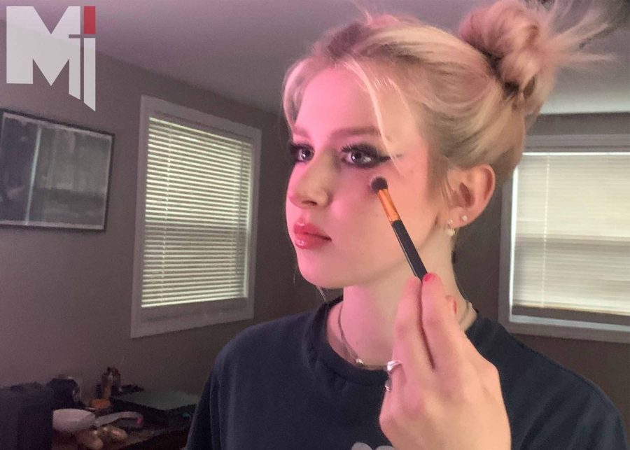 Freshman Grace Stella applies her makeup while looking in the mirror. 