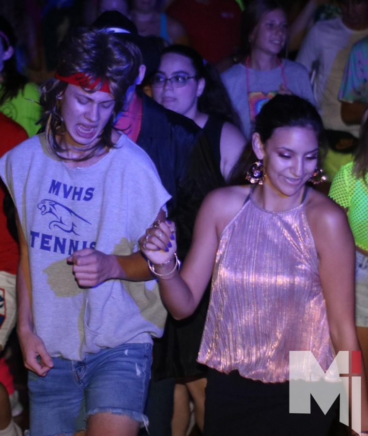Junior Isa Craig and sophomore Henry Holm show off their dance moves at the 80s Mixer. The playlist of the dance consisted of throwback songs from not only the 80s but the 00s as well.