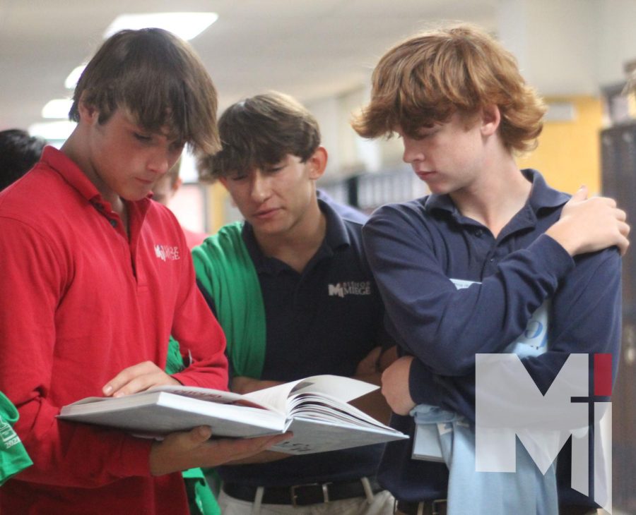 After receiving
 their herd shirts, juniors David Garcia, Hollis Moeller and Quintin Rhoades look through the yearbook during junior orientation on Aug.16.