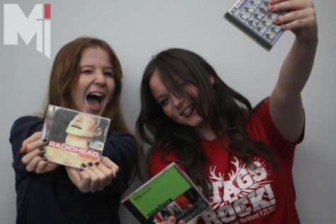 Junior Maggie Brennan and senior Lily Sumstine showcase some of their favorite CD albums.

