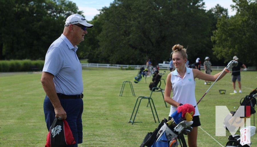 Preparing+for+an+upcoming+tournament%2C+freshman+Ashley+Myers+and+JV+golf+coach+Dennis+Mueller+talk+about+tips+for+the+driving+range.