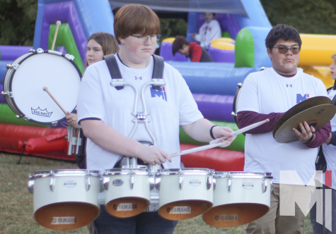 Preparing for the homecoming game, junior Luke Atwell practices the routine with the rest of the drumline. 