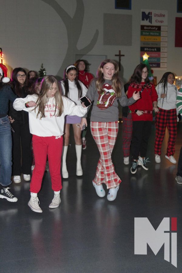 During the robotics club Christmas mixer, Emma Masters and Gabby Gallaher dance at the front of the dance line on Dec. 9. To raise funds, the robotics club decided to host a mixer for students to have an opportunity to celebrate the Christmas season. 