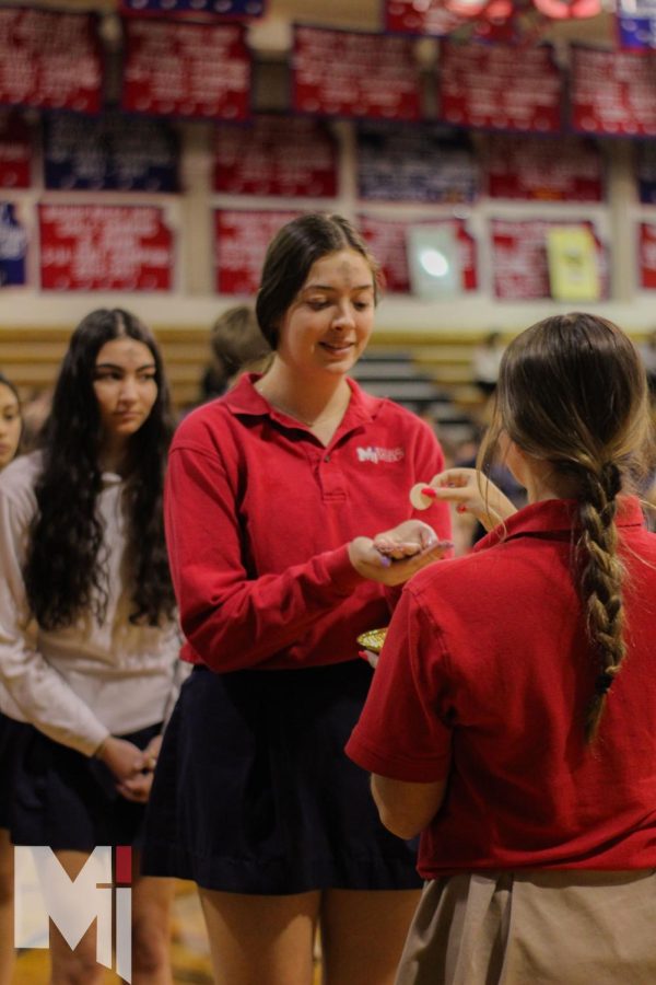 Smiling during Mass, junior Addison Burris is happy to receive her ashes and the body of Christ. Ash Wednesday service brought everyone in the school together to celebrate the beginning of Lent. My favorite part about Ash Wednesday is looking at what my ashes look like,  Burris said
