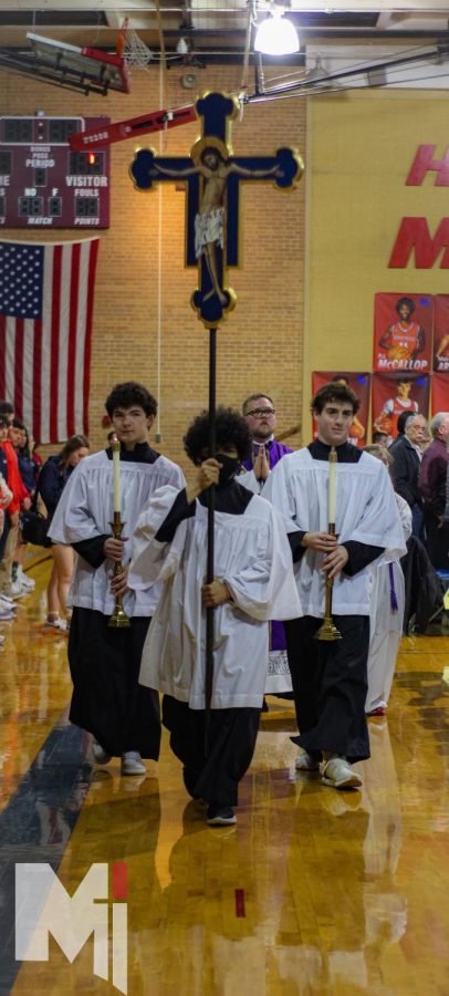 Serving Mass, seniors Jimmy Welsh, Dawson Utt, and John Swaney, walk out during the recessional. The three have all been involved in Mass this past year. My favorite part of serving is being able to serve God and the priest, Welsh said.