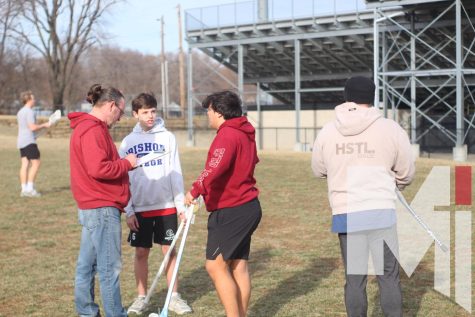 Clipboard in hand, head girls lacrosse coach Ross Dessert consults with freshman Nathan Brentano and Dominic Magana about recruiting more boys. The head boys lacrosse coach Jay Coleman and Dessert oversaw the lacrosse throw around on Feb. 21