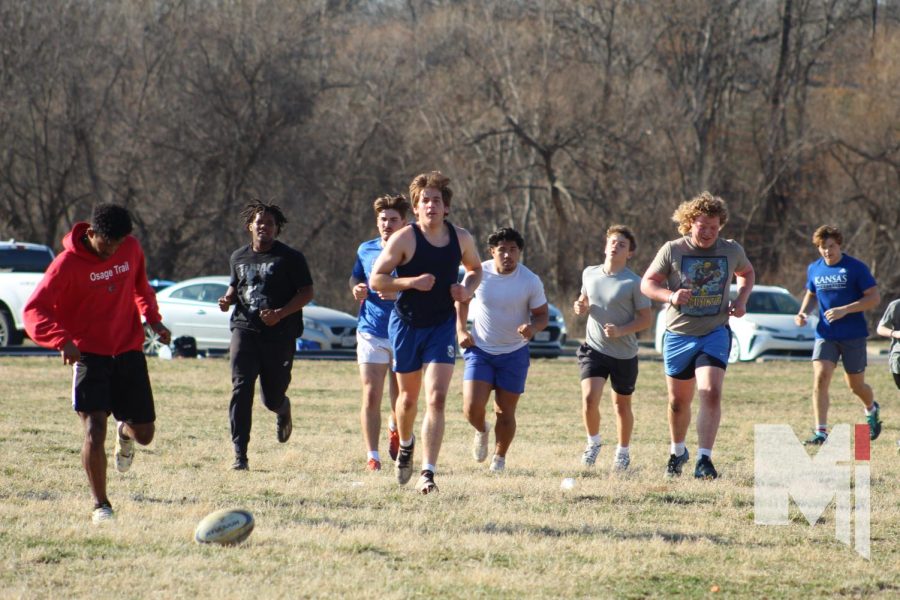 Jogging+a+lap+around+the+Blue+River+Athletic+field+in+Kansas+City%2C+Missouri%2C+the+Junior+Blues+Rugby+team+warms+up+before+starting+a+passing+drill.+The+club+team+practices+every+Tuesday+and+Thursday.+Senior+Edward+Murray+and+sophomore+Neil+Carman+are+members+of+this+club+team+that+practices+every+Tuesday+and+Thursday+from+3%3A30+p.m.+to+5%3A30+p.m.