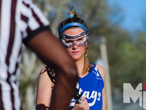 Glaring at her opponents, senior Grace Grams gets her stick checked before the game. Grams said she has twelve goals this season and plans on scoring more. “Obviously, I was getting locked in before the game,” Grams said. “I had my game face on.”
