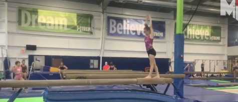 Freshman Mia Coniglio sticks her trick as she tumbles on the beam.