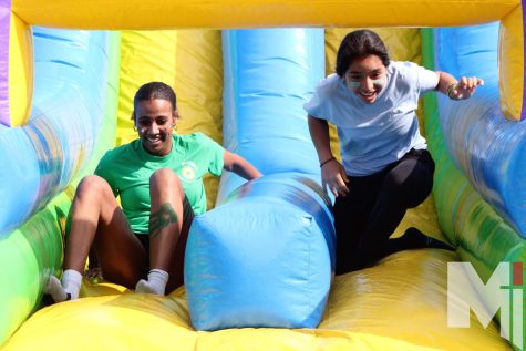 Racing to the finish line, sophomore Trinniti Stevens and junior Bibi Cervantes slide to the end of the obstacle course. The rock wall on the back was really hard, Stevens said. I had to win though, so I pushed through.