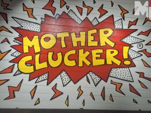 Mother Cluckers bright graphics on the interior of the building greet customers as they walk in. 