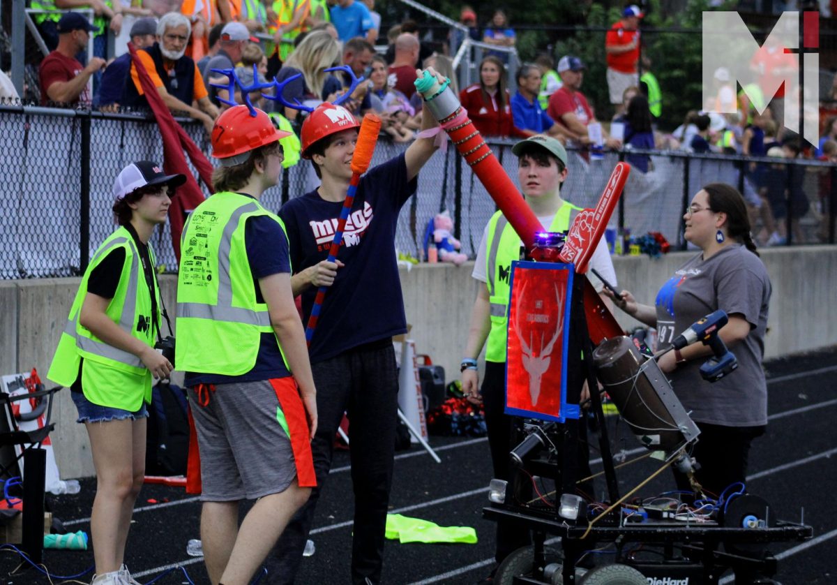 Shooting shirts into the crowds, the robotics team sets up its T-shirt cannon on the track and prepares to launch it into the crowd during the St. James football game Sept. 15.  