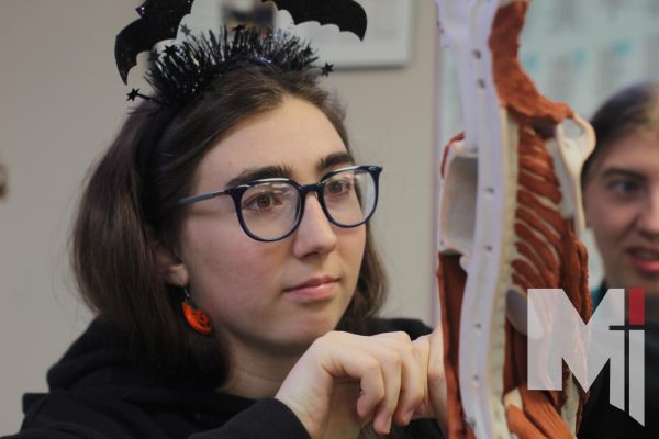 Junior Michaela Wilcox examines a skeleton model in new Human Body Systems class.