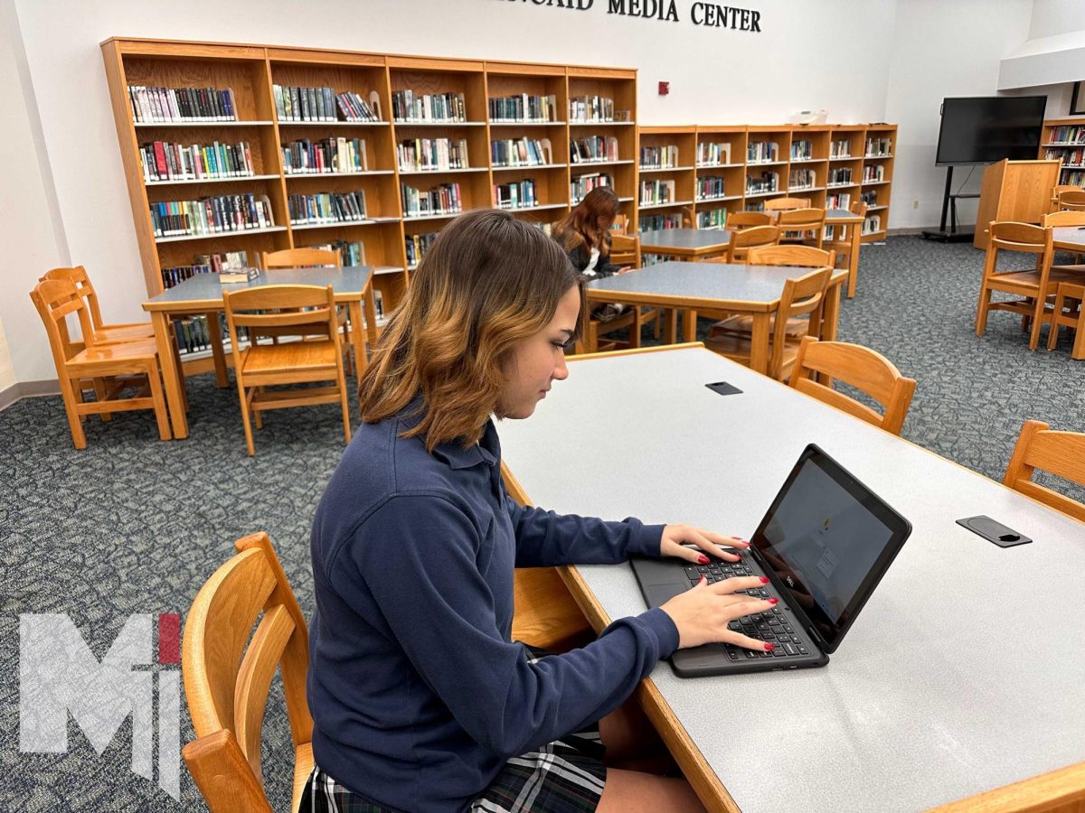 Sophomore transfer student Ava Holland sits in the Media Center and studies for finals. Her first semester at Miege is coming to an end. 