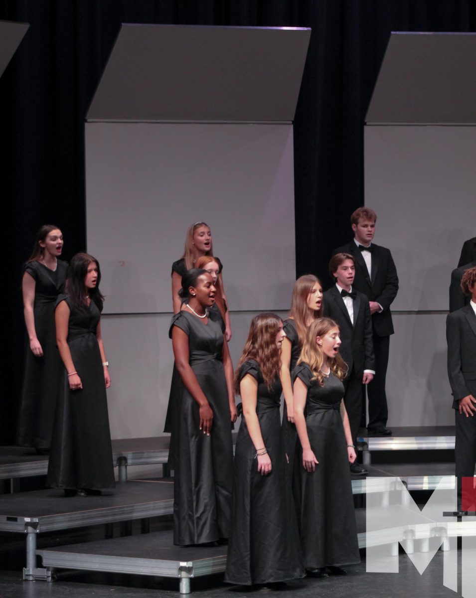 Singing in tune, senior Blythe Harris performs with the Cantare Deum choir during her last fall concert. “The choir is great, we blend well and all sound good together,” Harris said. “The environment is really good, everyone is nice to each other and uplifting.”