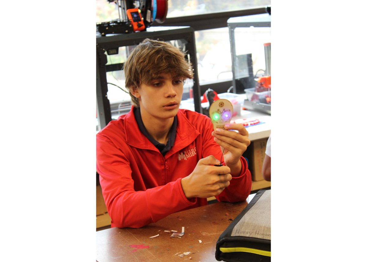 Sophomore Henry Hogard attaches LED strings to his sugar skull as a detail of his design in his Spanish class. 