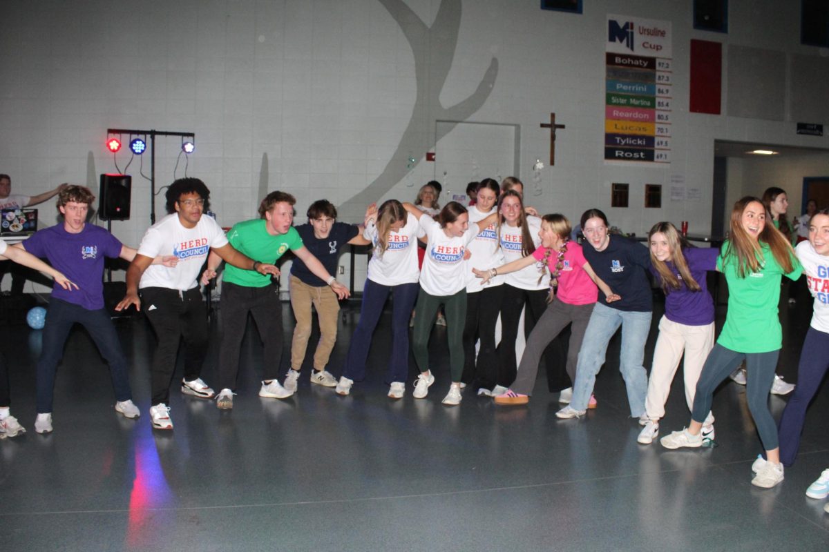 Enjoying the mixer, junior Devyn Davis (second from the left) gets the seventh and eighth-graders hyped up to dance. “It was kind of difficult to force them to get in there to dance because they all thought they were too cool to go dance,” Davis said. “It was fun for me and Finn to get lit, and as we were getting lit they joined in and it was a blast.”