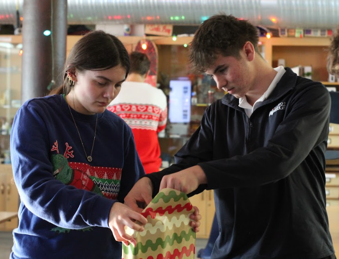 Carefully wrapping gifts, senior Addison Tindle dedicated to helping her community by donating items for Red Bag. “ I think Red Bag is important because we get to help out families in need, and it makes the kids feel special,” Tindle said. “I don’t think kids should have to worry about Christmas, and helping out like this takes stress off the parents’ shoulders.”
