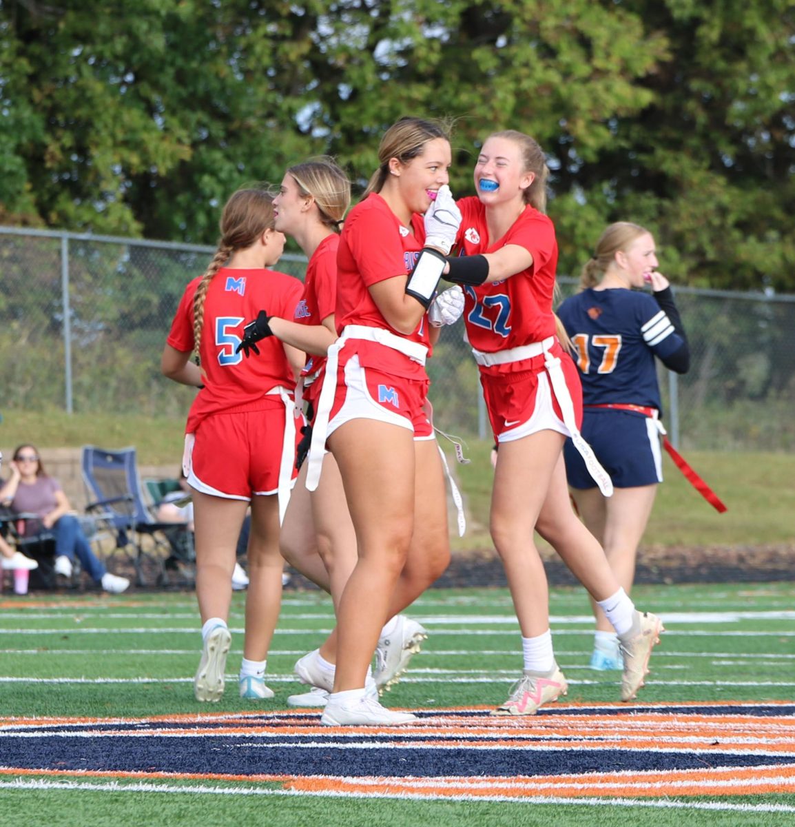 Hyped up.  Junior Josie Astor cheers on her teammate Olivia Buck after pulling an opponent's flag during the flag football game against Olathe East on Sept. 20. "I always feel excited for my teammates when they do good and I love to make them feel good about their plays," Astor said.