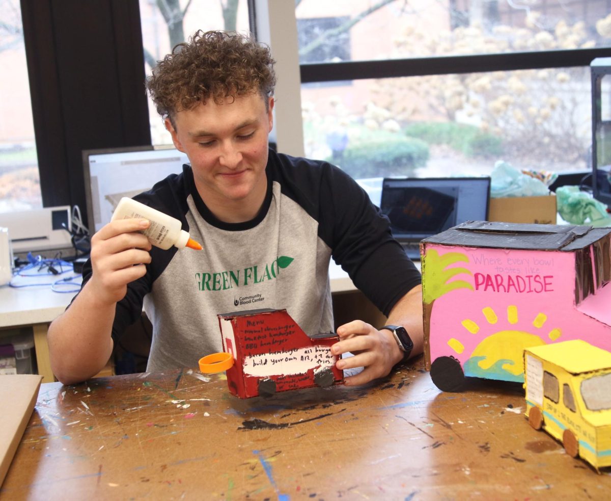 Senior Luke Nelson builds a food truck model in his Foods Two class. “Foods is a staple at Miege; I feel like it’s tradition to take it senior year and have fun with your friends,” Nelson said. “The food truck project made me realize how high inflation prices are and taught me how to budget expenses.”