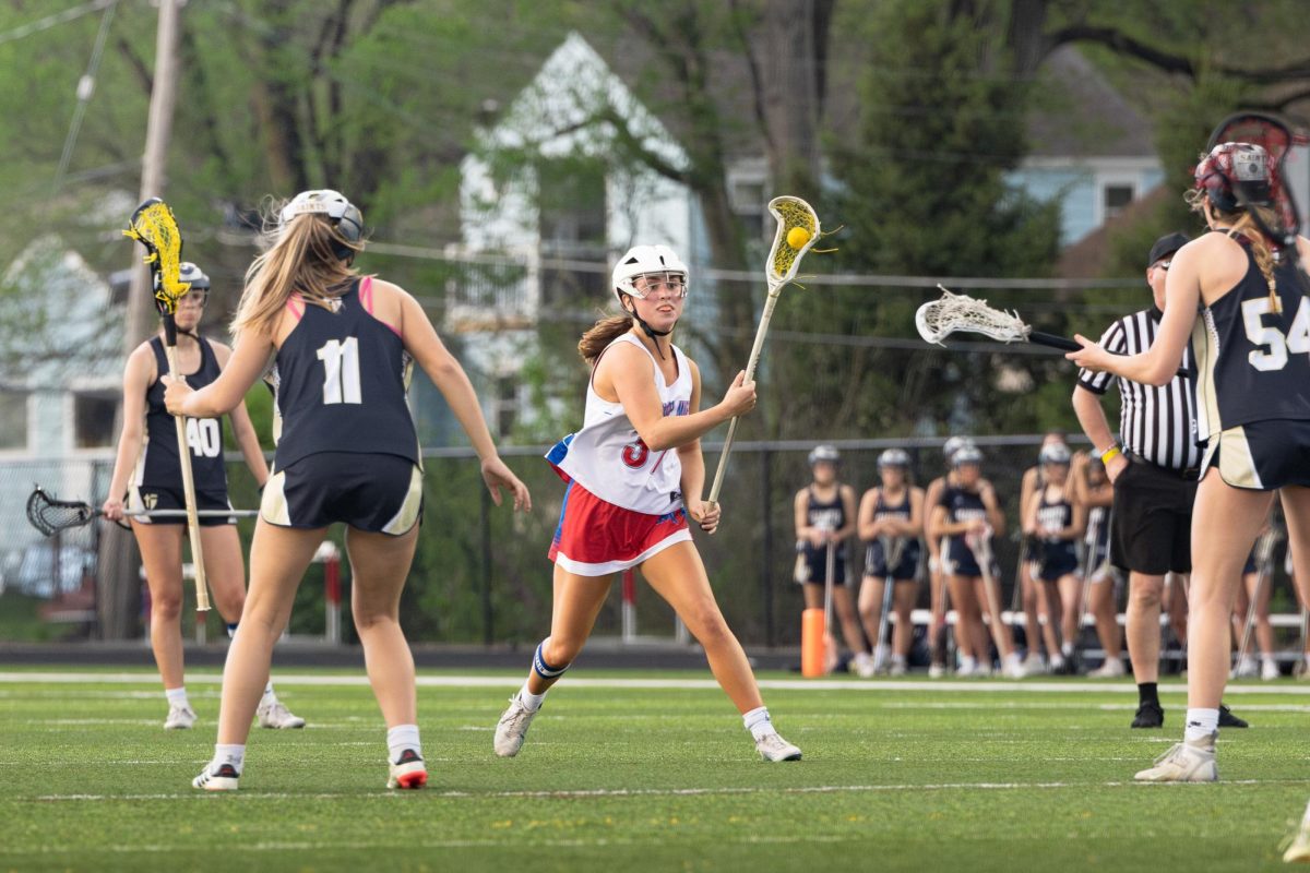 Driven to Lead. Team captain Mary Cate Dunn races down the field with the ball during the game against St. Thomas Aquinas on April 13. “I love the high energy that can come out of intense games, like when people get super passionate and run out to hype up their teammate on goals or good plays,” Dunn said. “Being a senior has felt like an older sister moment for me since I know the younger girls look to you for guidance.