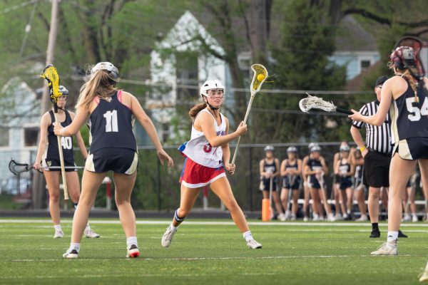Driven to Lead. Team captain Mary Cate Dunn races down the field with the ball during the game against St. Thomas Aquinas on April 13. “I love the high energy that can come out of intense games, like when people get super passionate and run out to hype up their teammate on goals or good plays,” Dunn said. “Being a senior has felt like an older sister moment for me since I know the younger girls look to you for guidance.